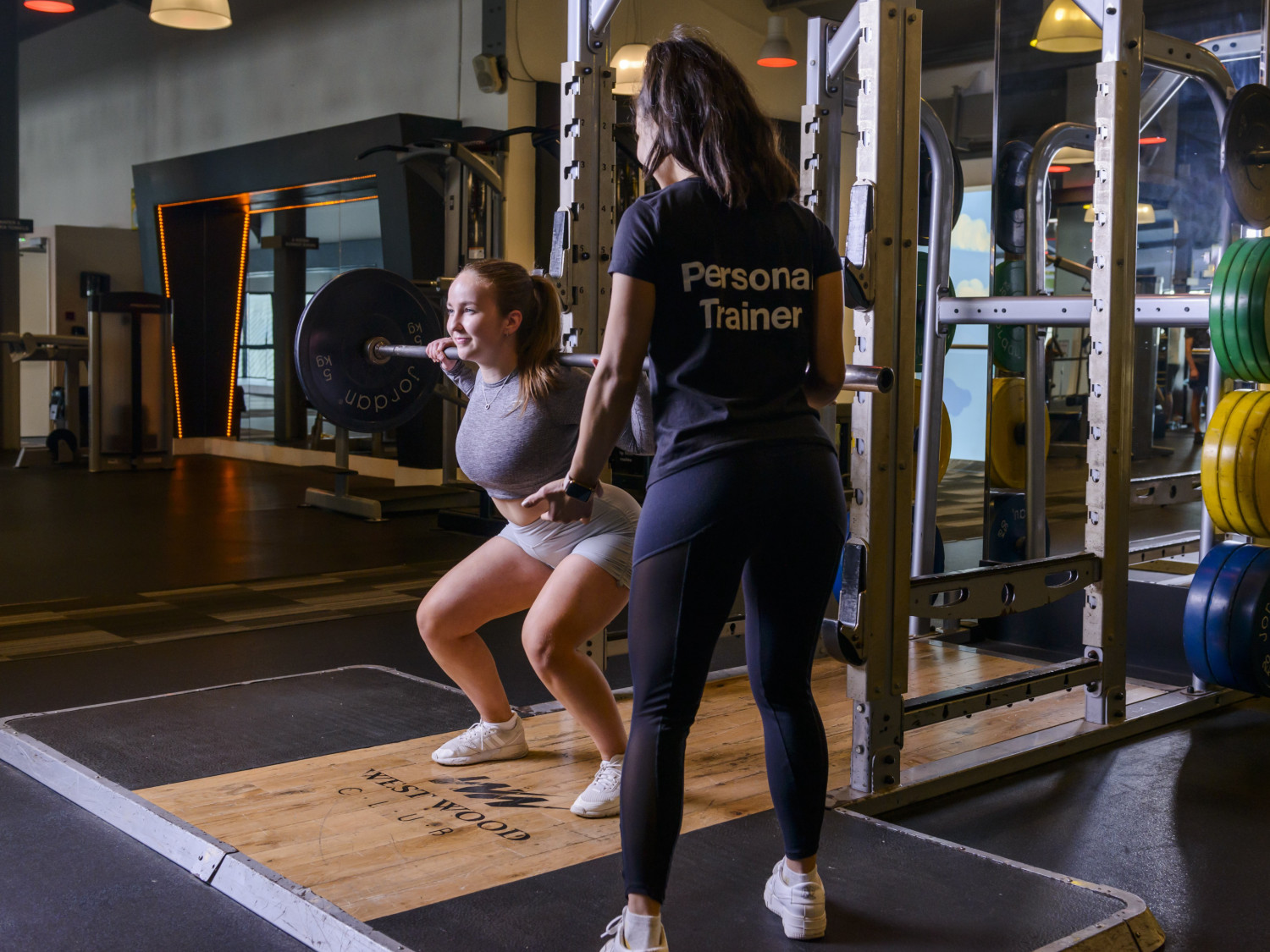 Personal Trainer at west Wood Club with female client squatting